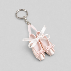Fresh ballet pointe shoe keychain featuring a pair of pale pink satin miniature ballet slippers with white satin ribbons on a silver keyring