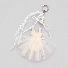ballet tutu bag charm in cream with lace top, tulle skirt, ribbons, and pearl accents on keyring