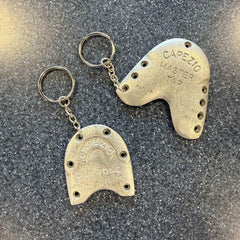 Tap Dance Keychain made from silver metal worn tap shoe parts with engraved text and attached keyring on speckled surface